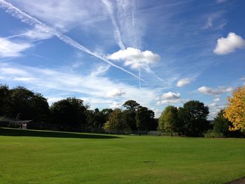 Scenic view of grassy field against cloudy sky