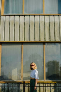 Portrait of woman standing against railing