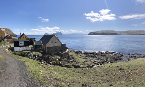 Houses by sea against sky