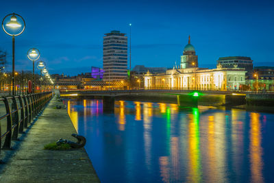 Illuminated buildings by river at night