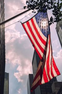 Low angle view of flags against cloudy sky