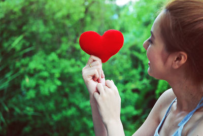 Midsection of woman holding heart shape