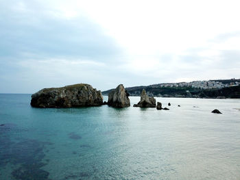 Rocks in sea against sky
