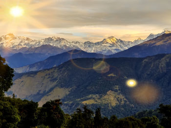 Scenic view of snowcapped mountains against sky during sunset