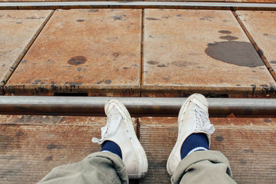 Low section of man standing on wood