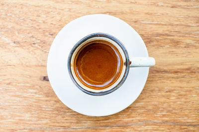 A cup of hot espresso coffee on wooden background.