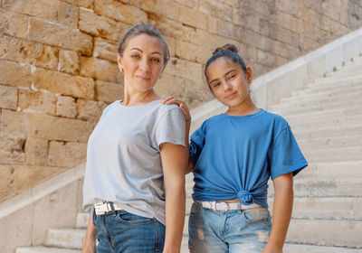 Portrait of mother and daughter standing outdoors