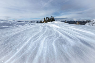 Snow covered land against sky