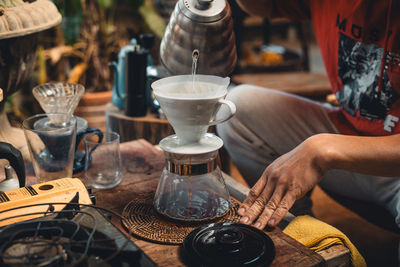 Cropped hand of woman holding coffee on table