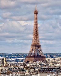 Eiffel tower against cloudy sky