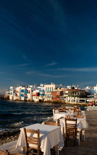 View of restaurant by sea against buildings in city