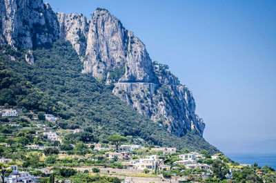 Townscape by mountain against clear sky