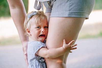 Portrait of baby girl crying while embracing mother