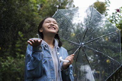 Full length of a smiling young woman in rain