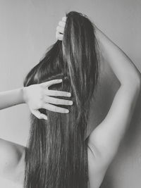 Rear view of woman holding hair