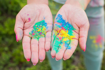 Close-up of hand holding multi colored flower