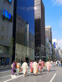 People walking on road against buildings