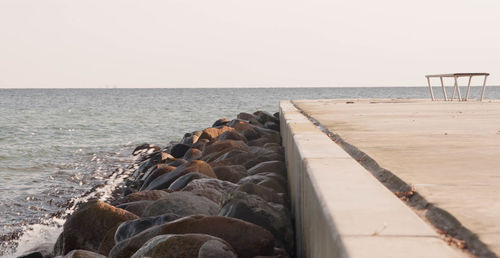 Groyne in sea against clear sky