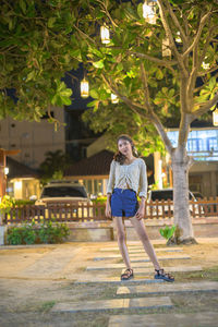 Full length portrait of teenage girl standing against built structure