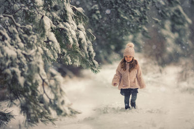 Full length portrait of girl standing in snow