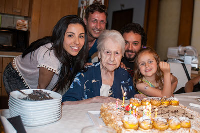 Portrait of smiling friends sitting on table