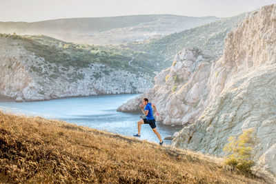 Man standing on rock by mountains