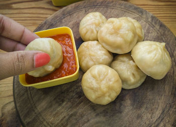 High angle view of person holding bread on table