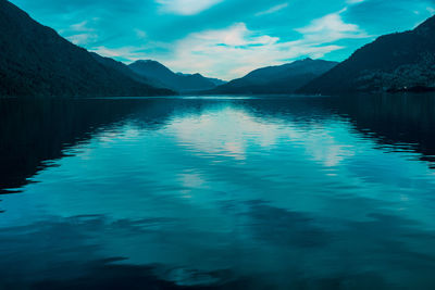 Scenic view of lake by mountains against sky