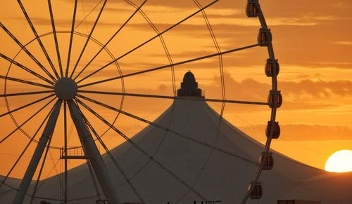 Low angle view of ferris wheel against sky during sunset