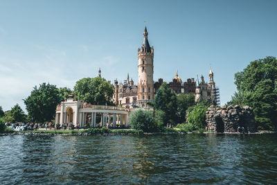 View of building by river against sky