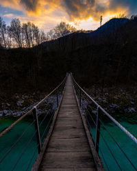 Bridge over footbridge against sky during sunset