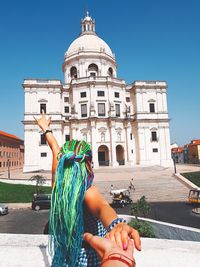 Low angle view of woman against buildings in city