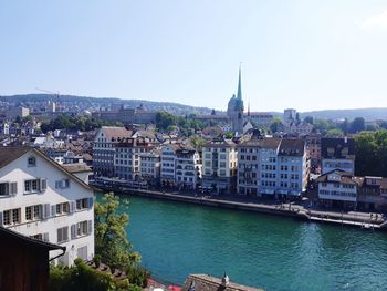 River amidst buildings in town against clear sky