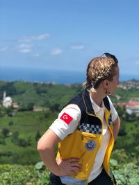 Low section of boy standing on land against sky