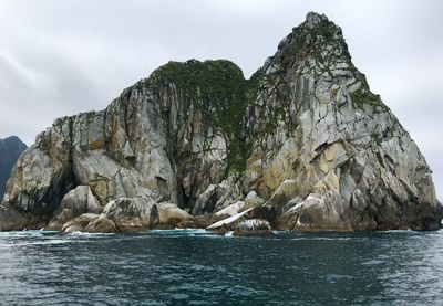 Scenic view of rock formation in sea against sky