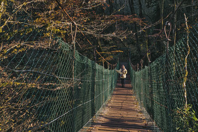 Rear view of footbridge in forest