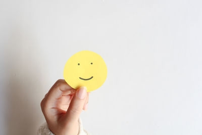 Cropped hand holding heart shape against white background