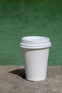 Close-up of disposable cup on retaining wall