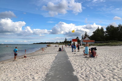 People on beach against sky