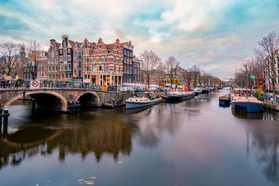 Bridge over river in city against sky