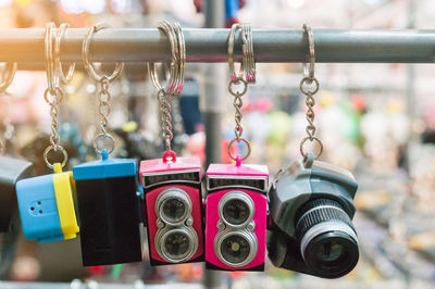 Close-up of camera key rings hanging for sale at market stall