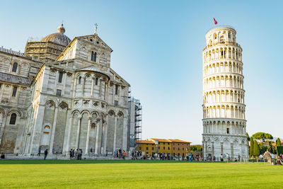 People in front of historical building against clear sky