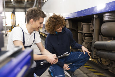 Engineer showing monorail engine to trainee in industry