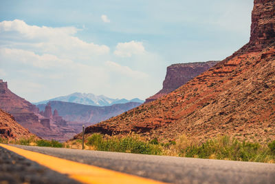 Road by mountains against sky