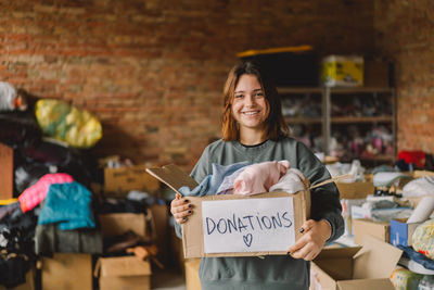 Volunteer teengirl preparing donation boxes for people.