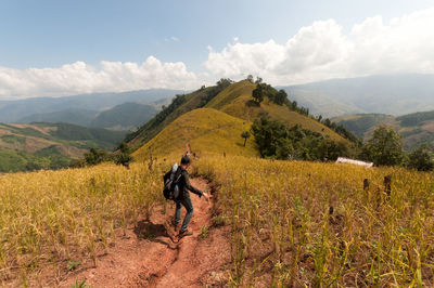 Man riding horse on mountain against sky