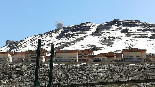 Houses on snowcapped mountain against sky