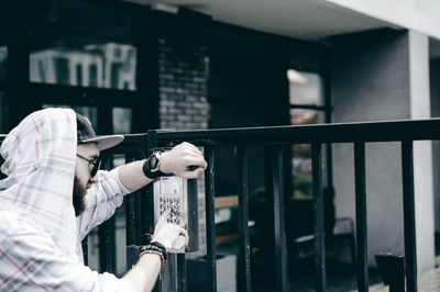 Close-up of woman photographing against built structure