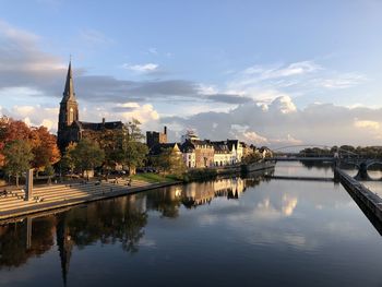 Reflection of buildings in city at sunset