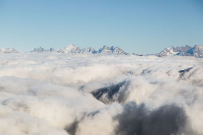 Scenic view of snowcapped mountains against blue sky